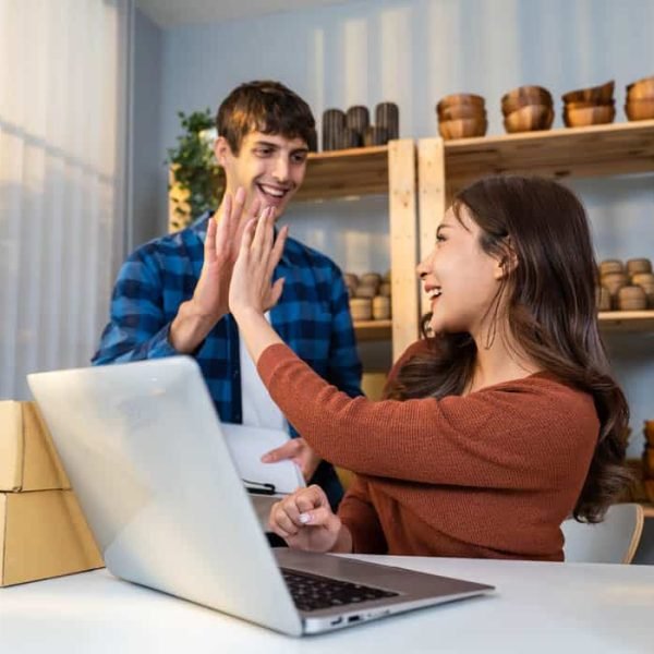 Attractive young couple packing vase goods order into box for customer. Employee businessman and woman working to preparing parcel boxes checking ecommerce shipping online retail to sell at home store